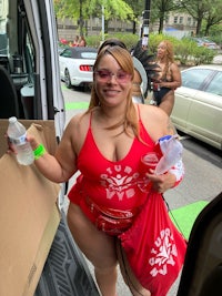 a woman in a red bikini standing next to a van