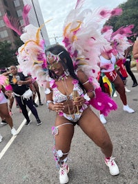 a woman in a colorful costume is dancing in a parade