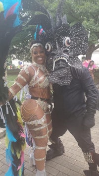 a man and woman dressed in carnival costumes pose for a photo