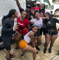 a group of people posing in front of a white van