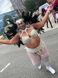 a woman in a feathered costume posing in the street