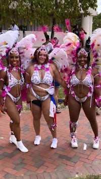 three women in colorful costumes pose for a photo